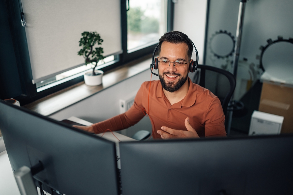 Happy,Entrepreneur,Wearing,Headset,And,Using,Computer,While,Working,Remotely Customer service representative